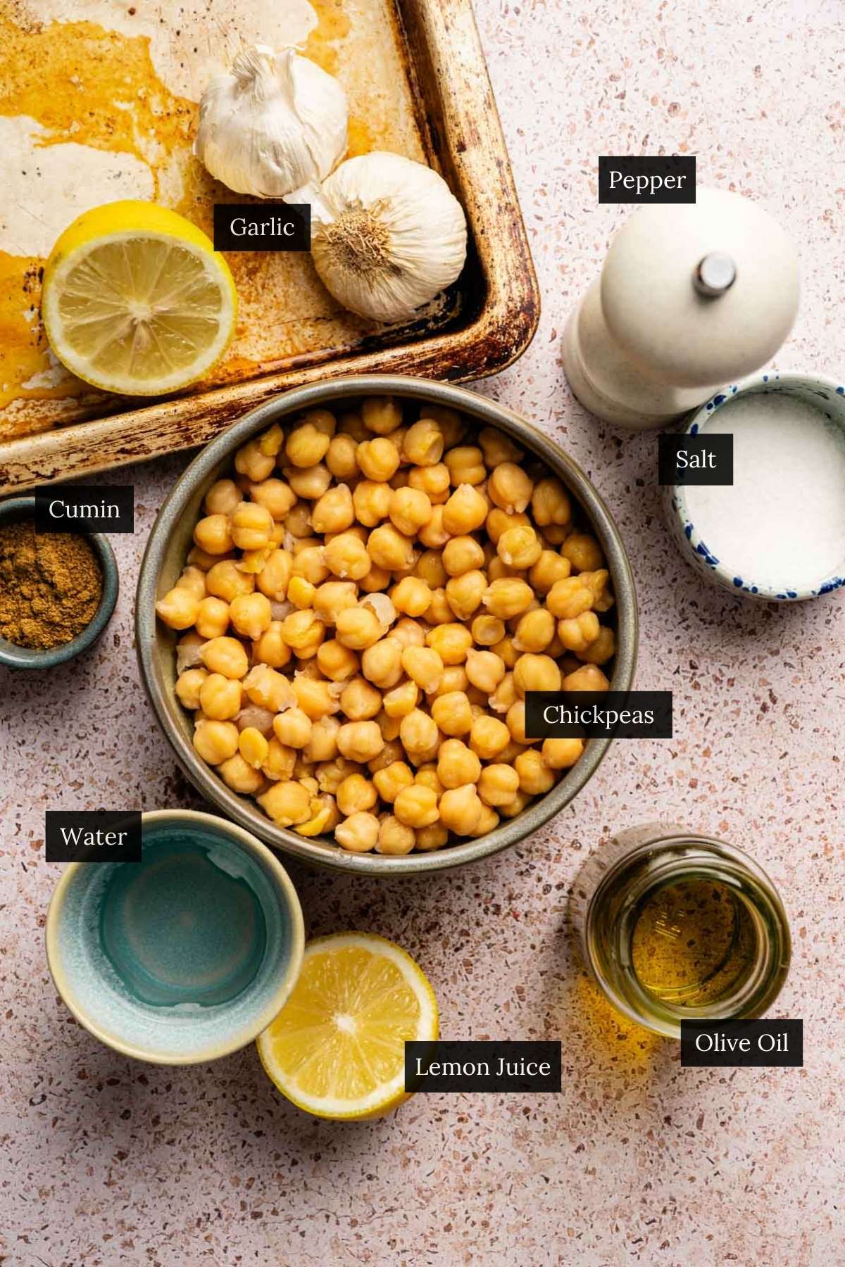Ingredients for roasted garlic hummus recipe without tahini with each ingredient labeled.