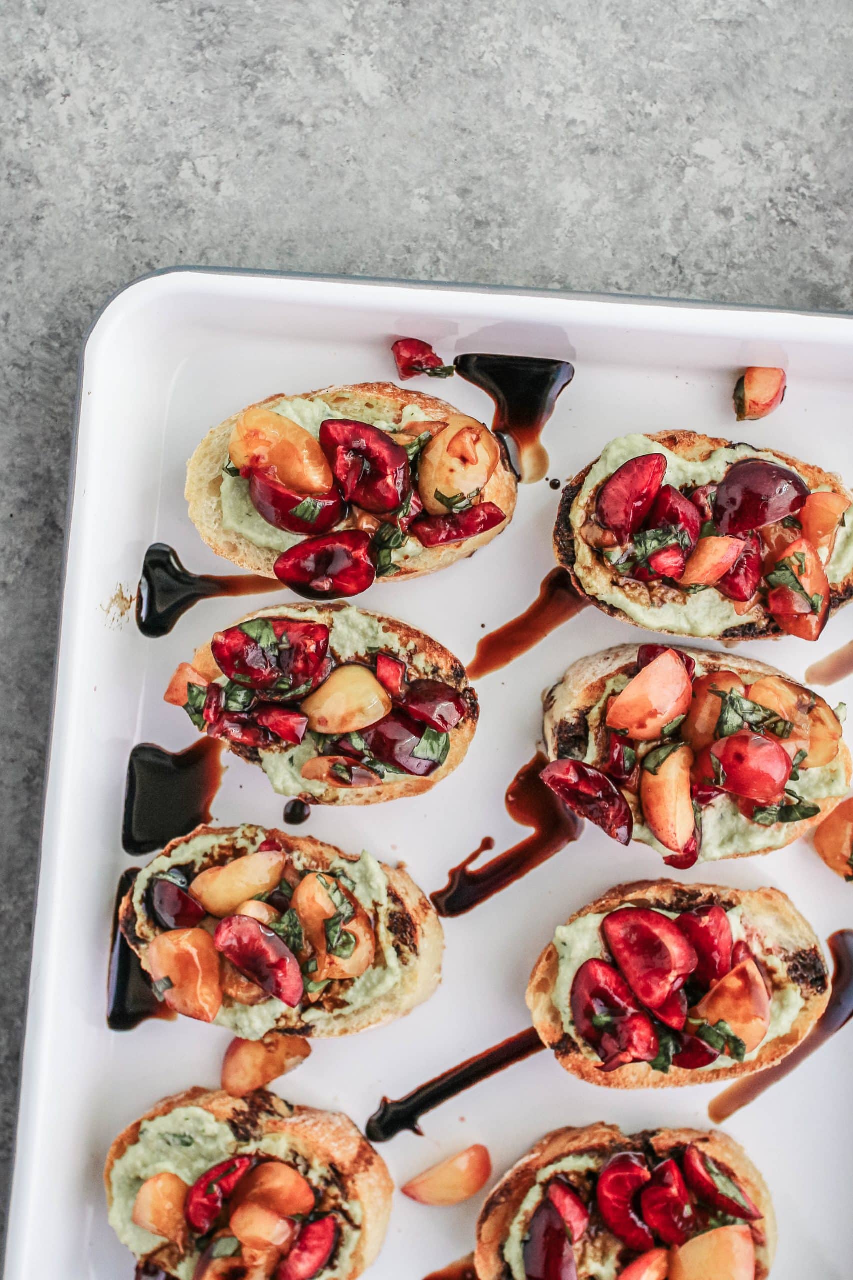 Cherry bruschetta with a balsamic glaze on a white enamel tray