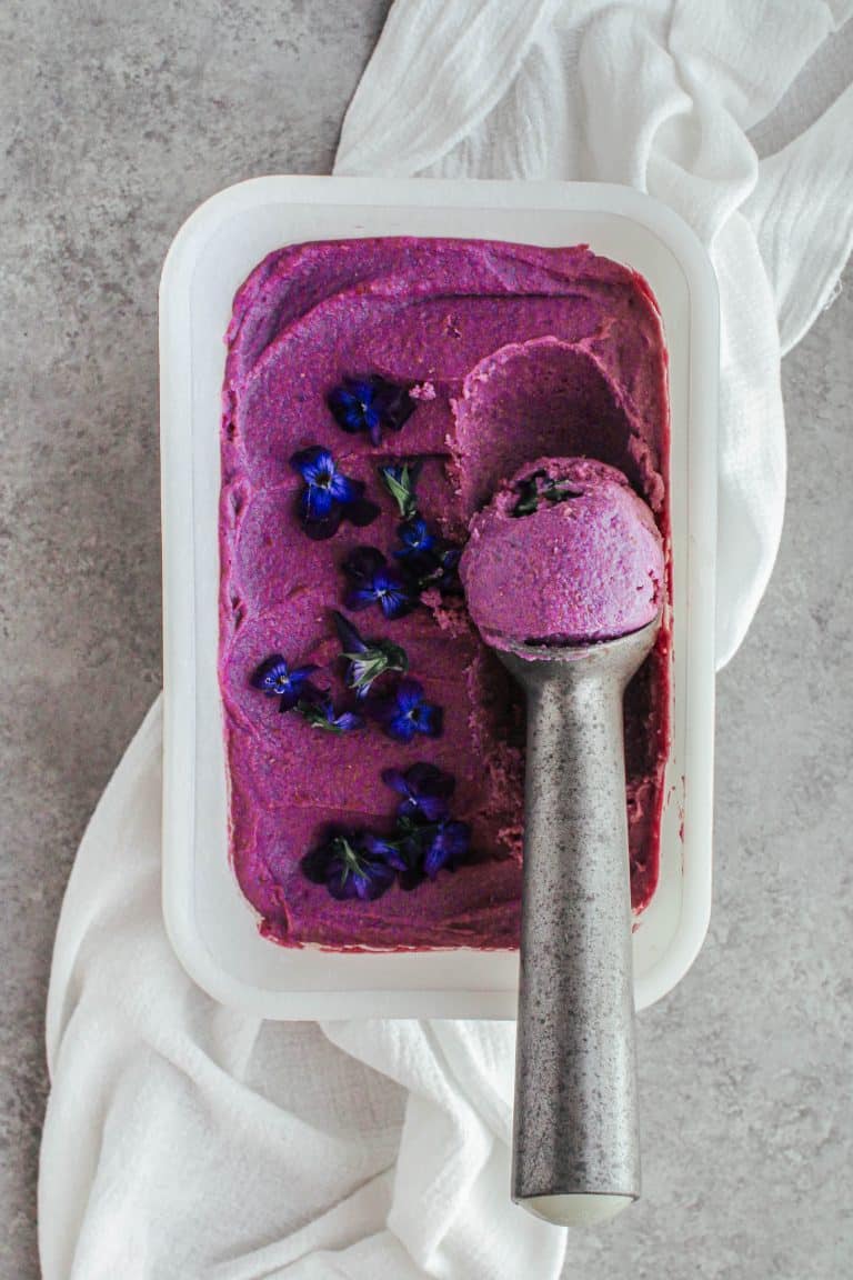 Close up of purple sweet potato ice cream with a scoop taken out.