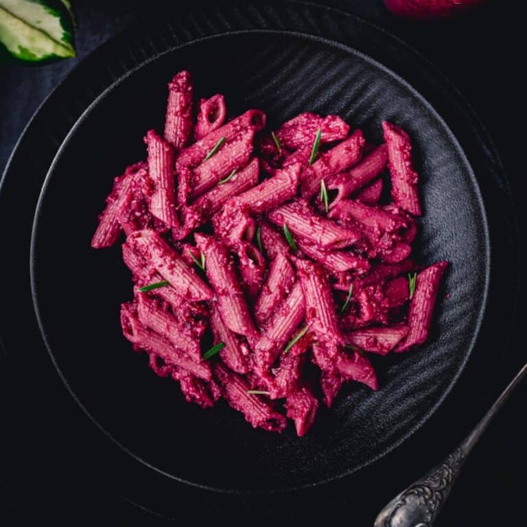 Black plate of pink noodles.