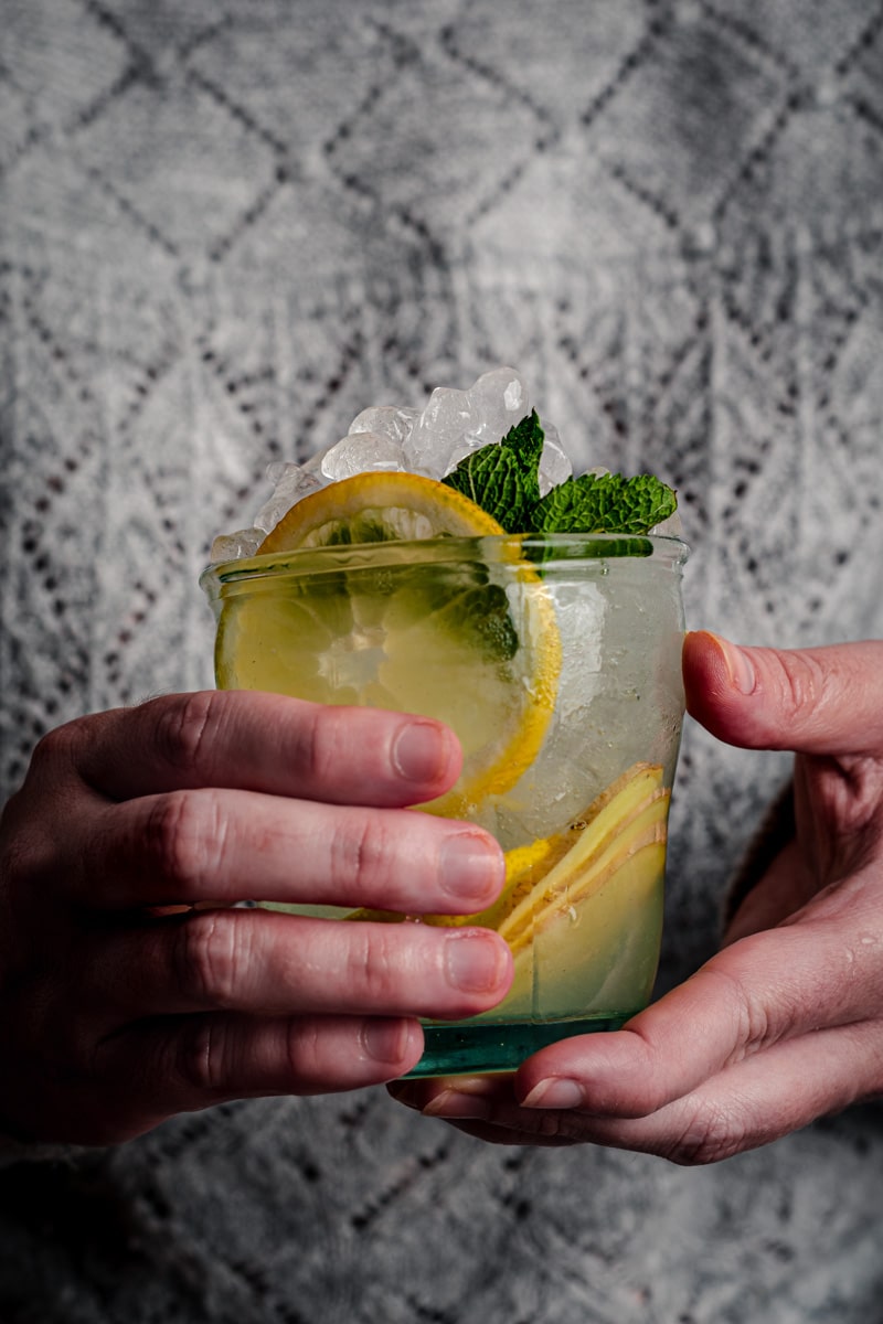 Woman holding a cup of ginger lemonade.