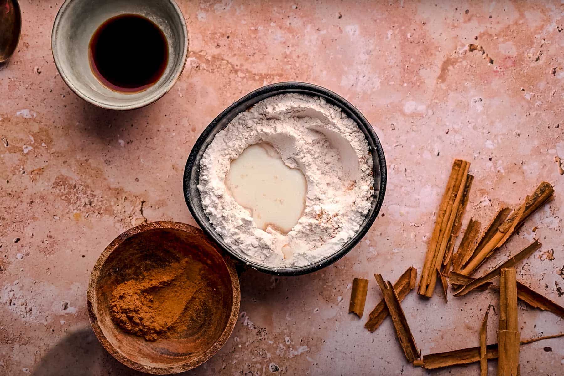 A bowl of powdered sugar with milk in the center.