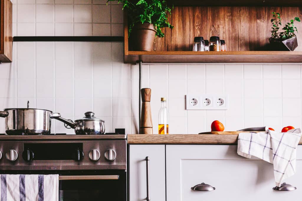 Scandinavian kitchen with stainless steel pots on the range.