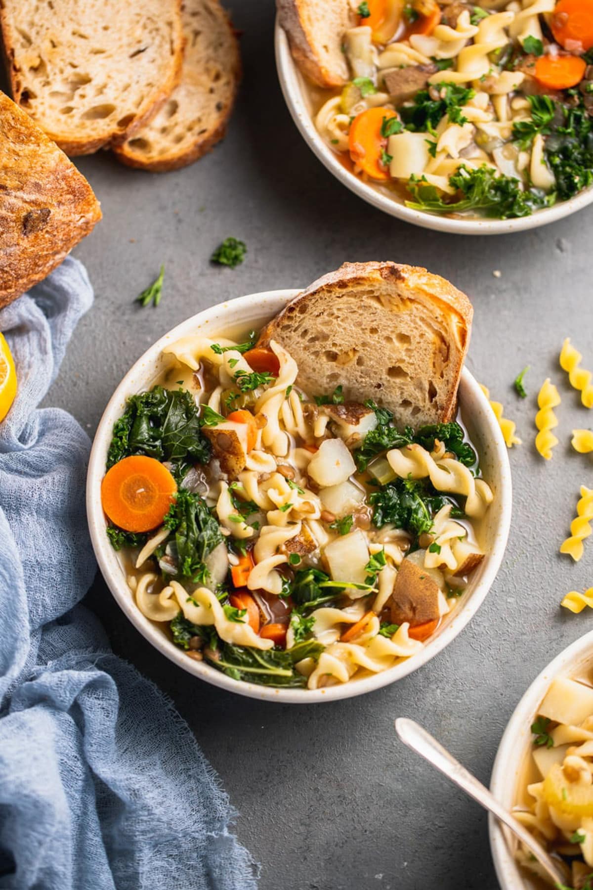 Full bowl of vegetable noodles soup with toasted dipped in it.