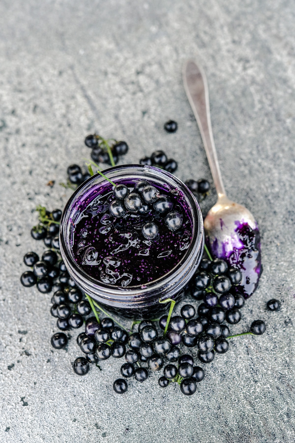 Chichiquelite garden berries made into a jam in a glass jar with fresh ones next to it.