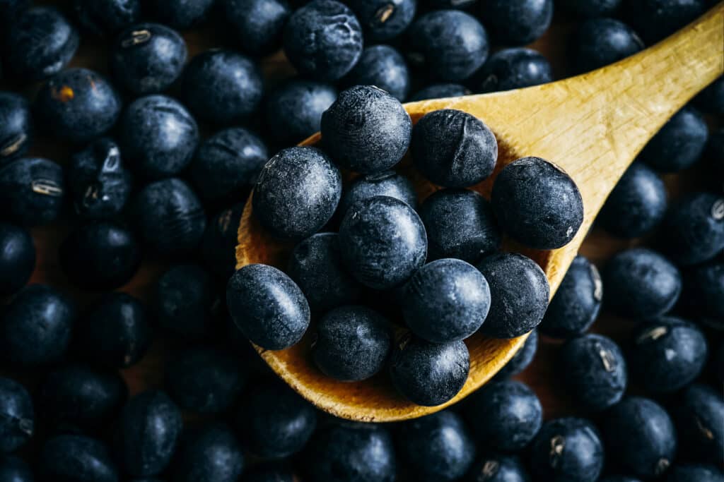 Black edamame with a wooden spoon.
