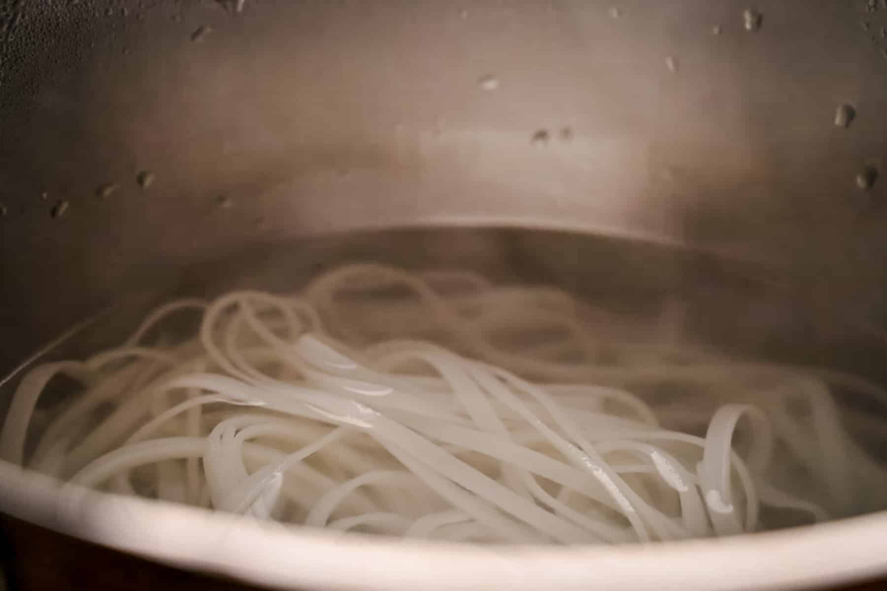 Large pot of rice noodles cooking.