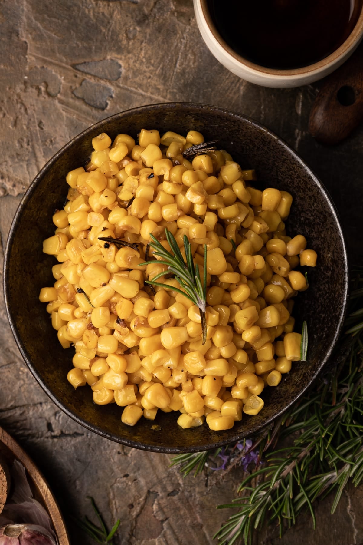 Up close of bronze bowl filled with cooked canned corn.