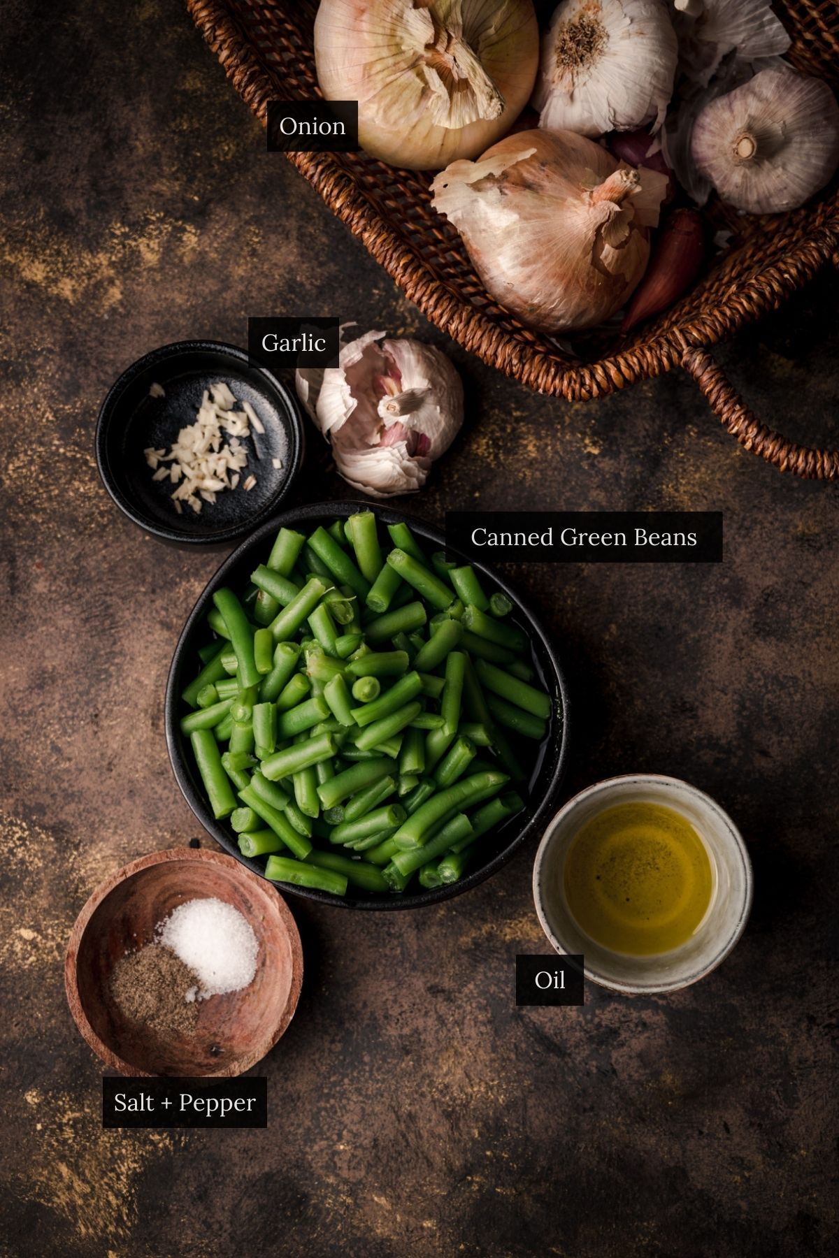 Bowl of canned green beans with ingredients in small bowls surrounding it.