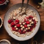 Large bowl of oatmeal with chia seeds and raspberries on top.