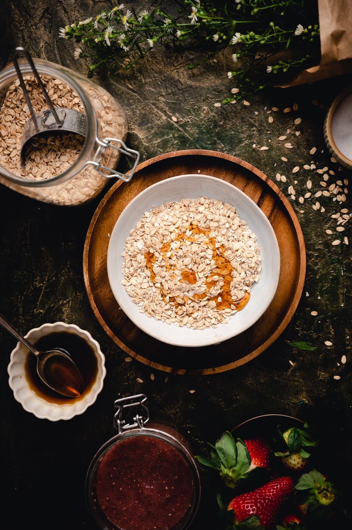 Rolled oats in a bowl with maple syrup added.
