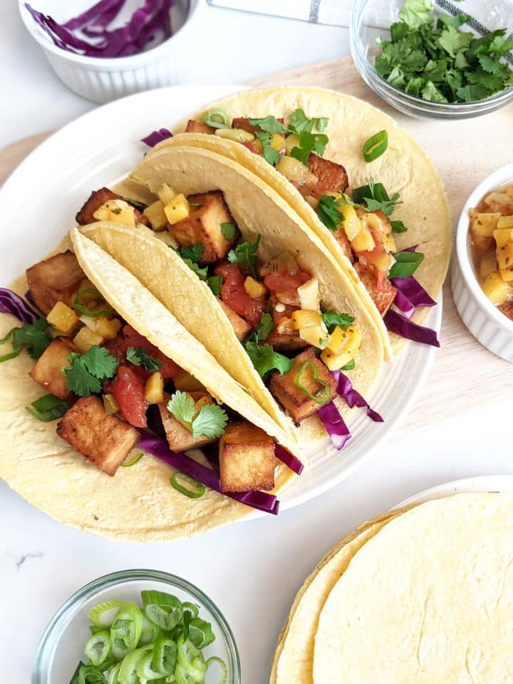 Vegan tofu tacos on a white plate.