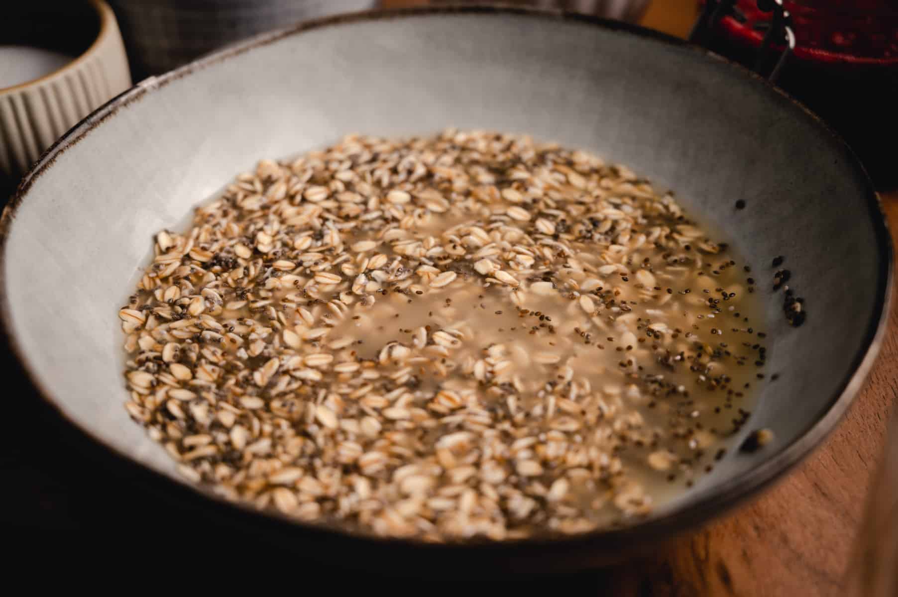 Bowl of old fashioned oats with chia seeds, maple, syrup, and hot water added.