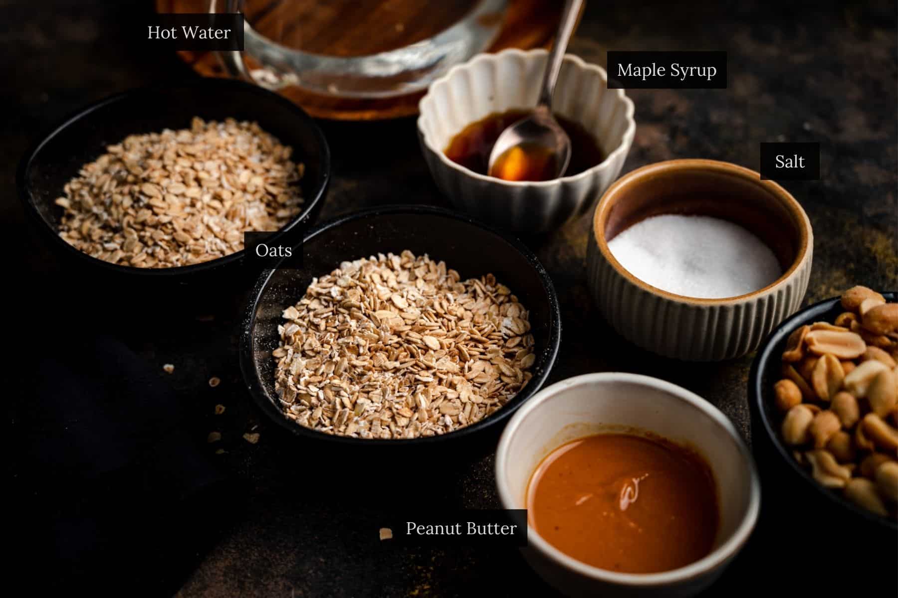 Ingredients for making peanut butter oatmeal in small bowls on a wooden table.