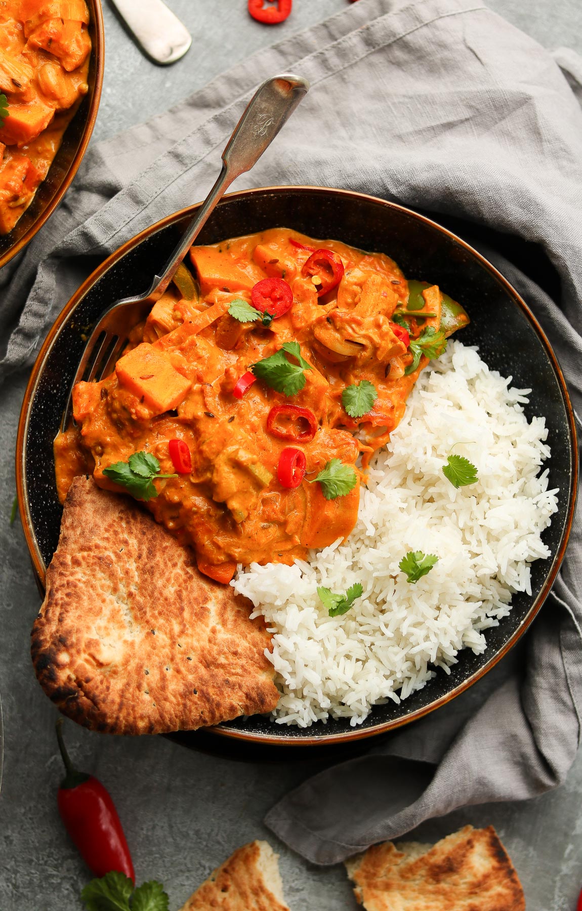 Bowl of rice, bread, and vibrant orange curry.