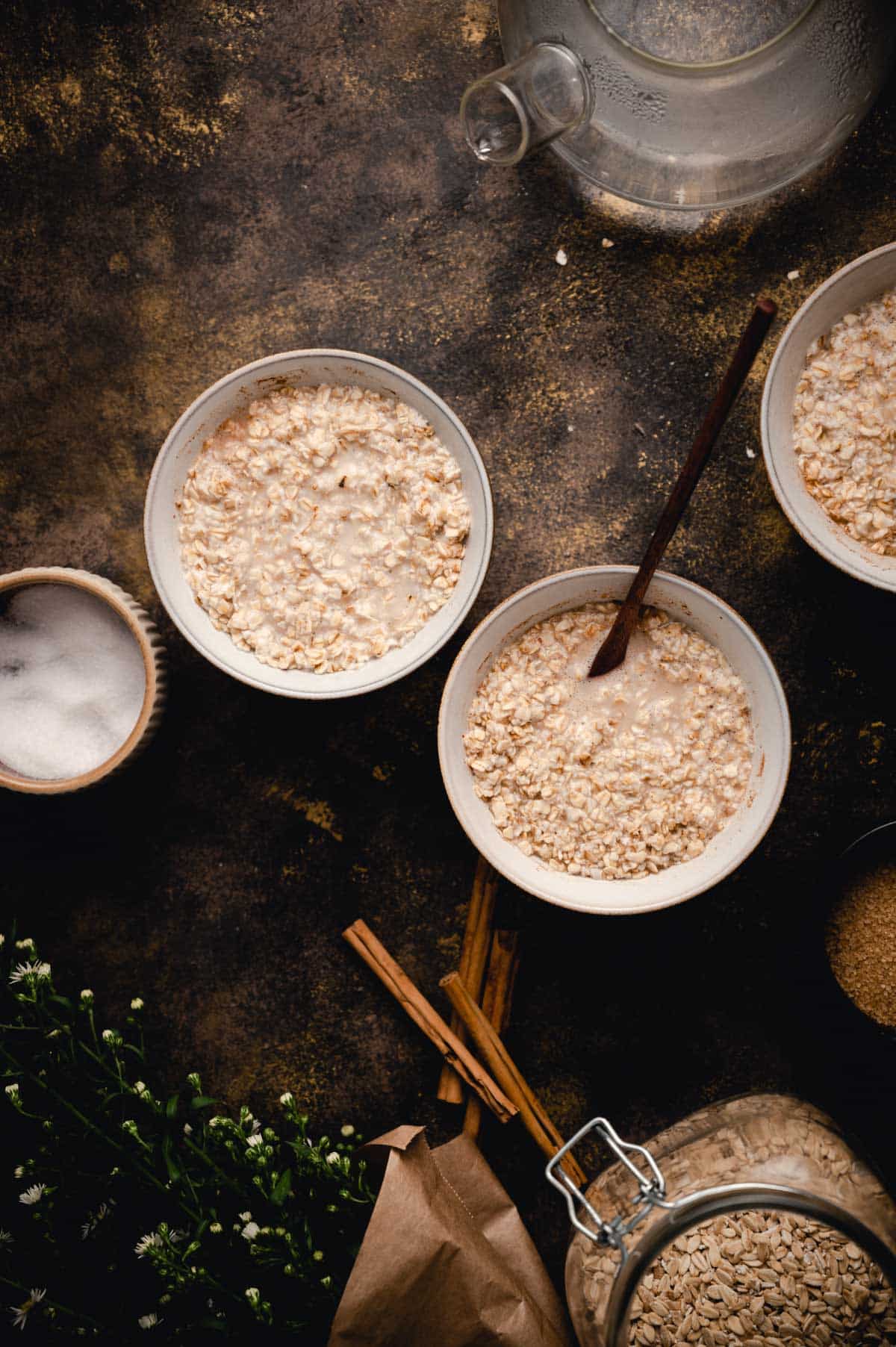 Three bowls of oatmeal are placed on a dark surface.