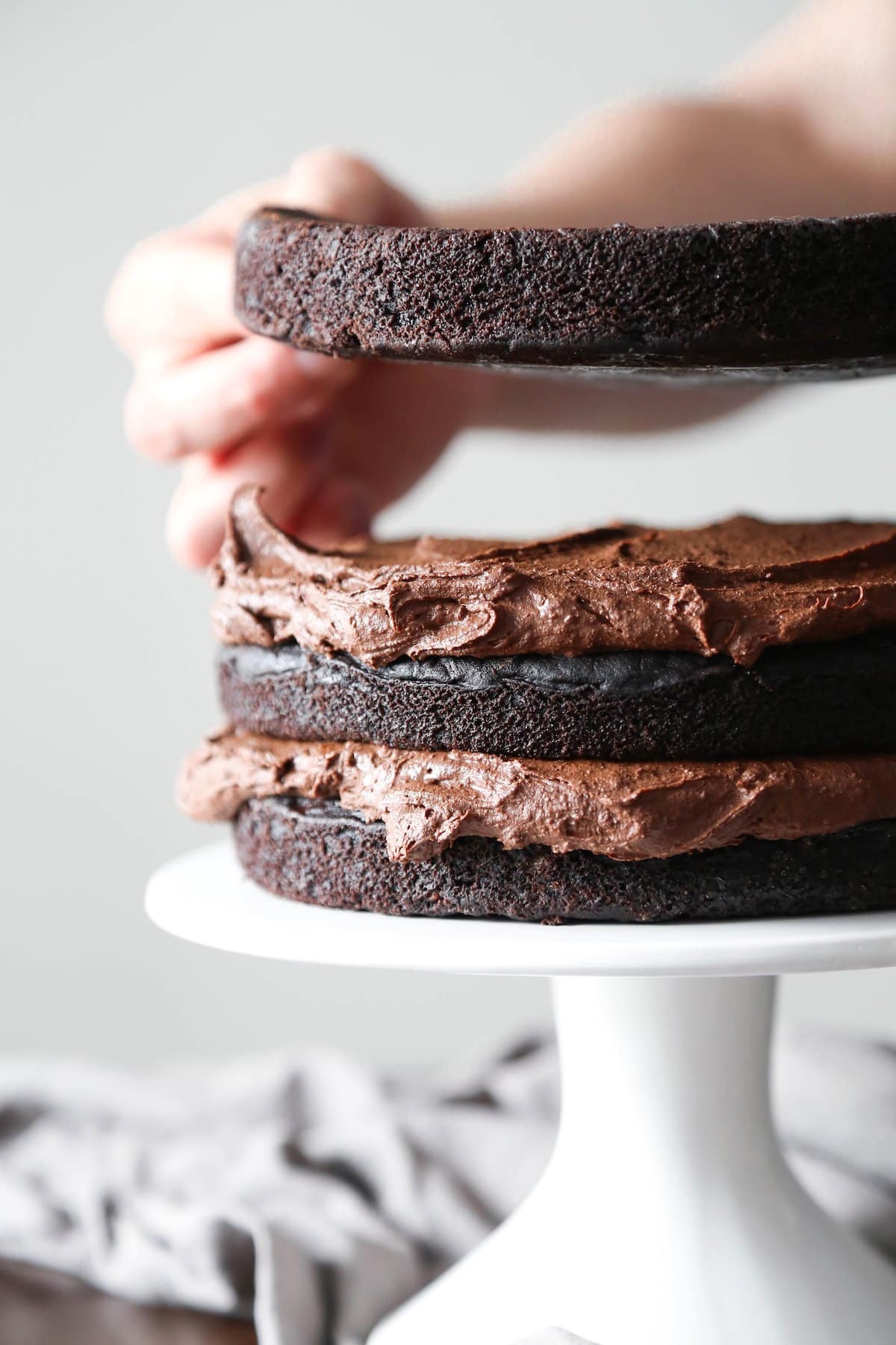 Three layer chocolate vegan cake with chocolate ganache frosting.