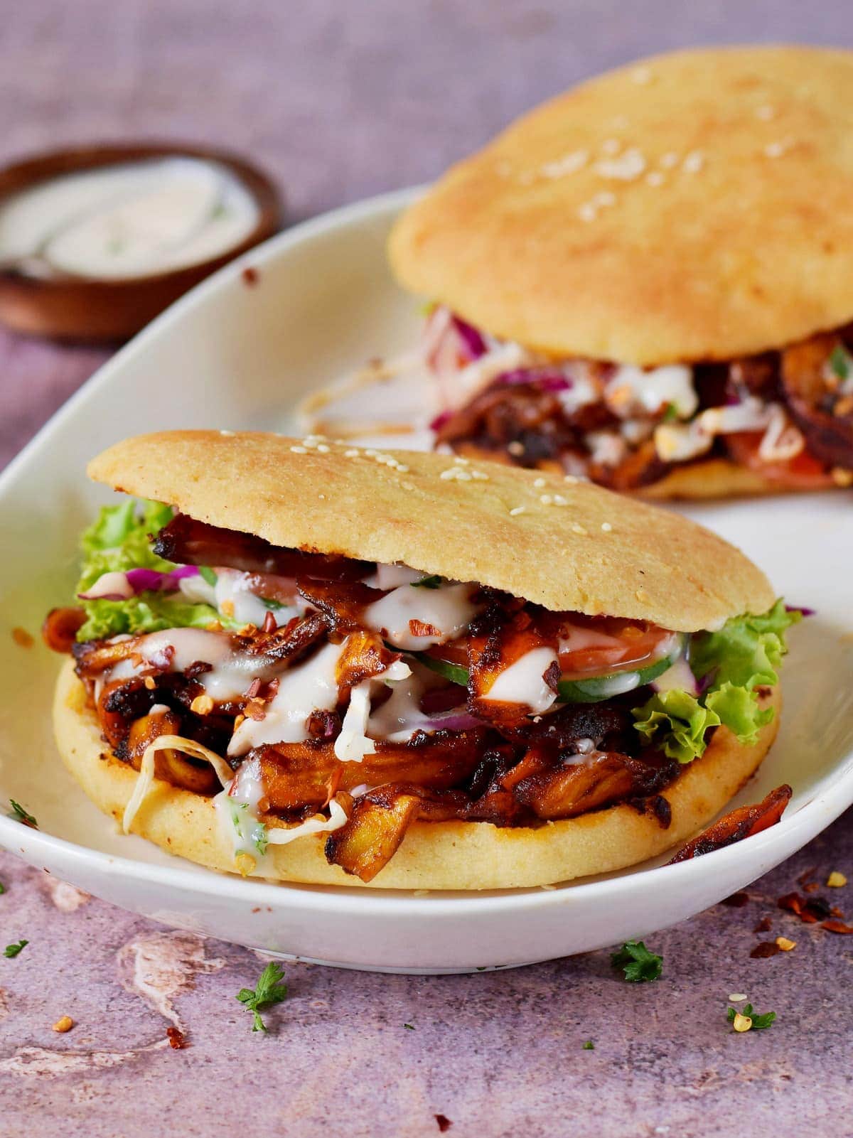 Two jackfruit shawarmas on an oval plate.