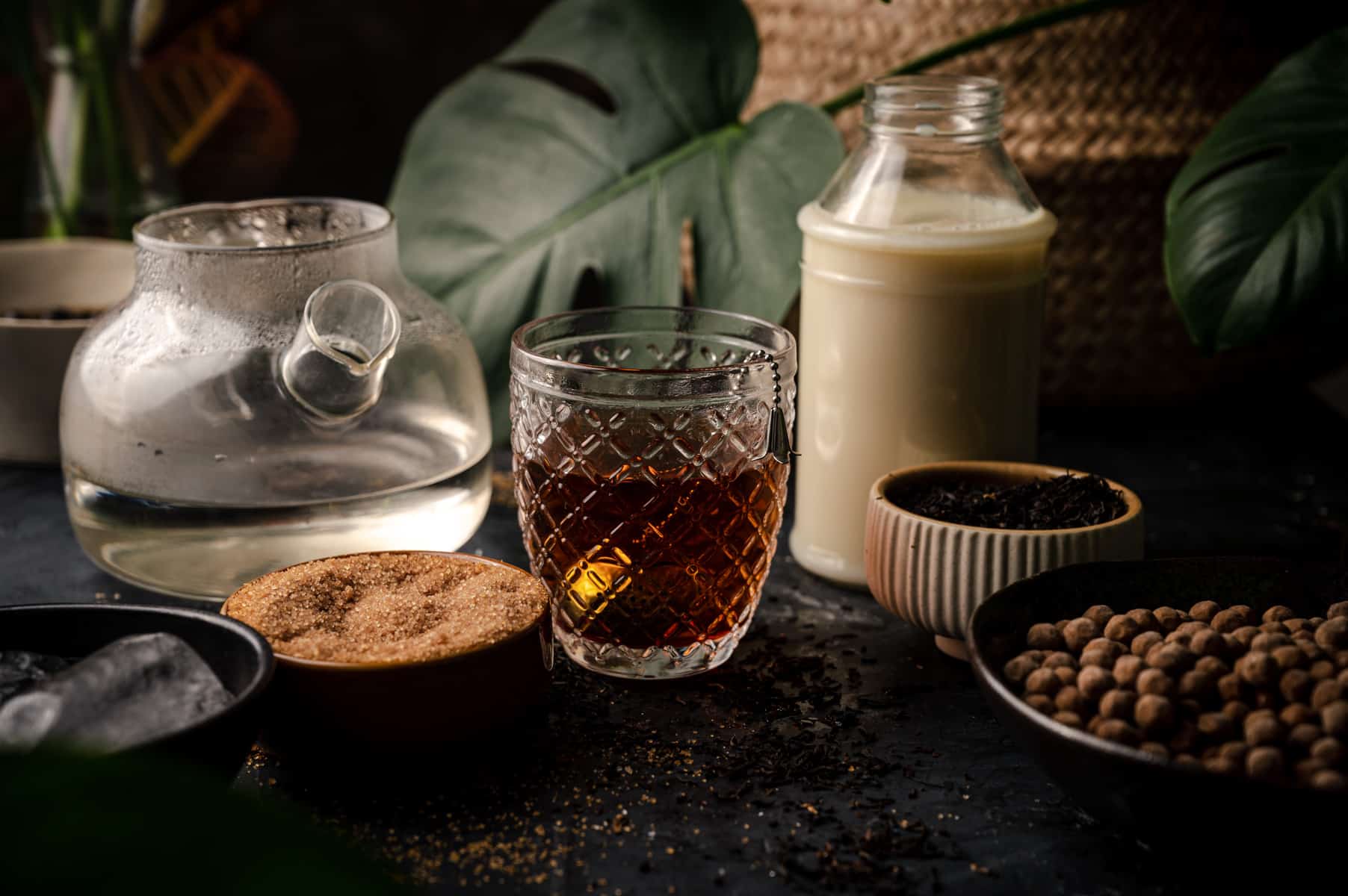 Deep caramel brown oolong tea with ingredients surrounding it.