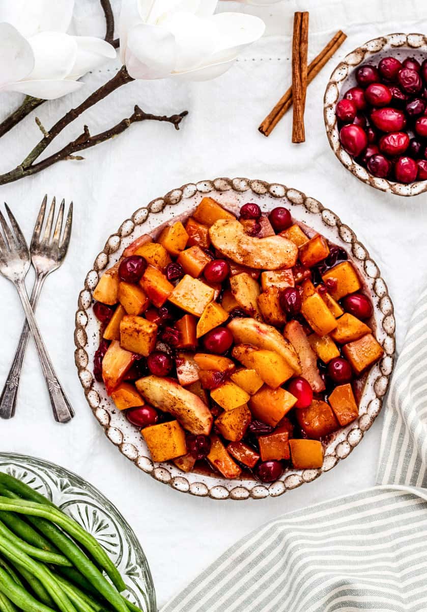 A plate with cranberries, apples and green beans.