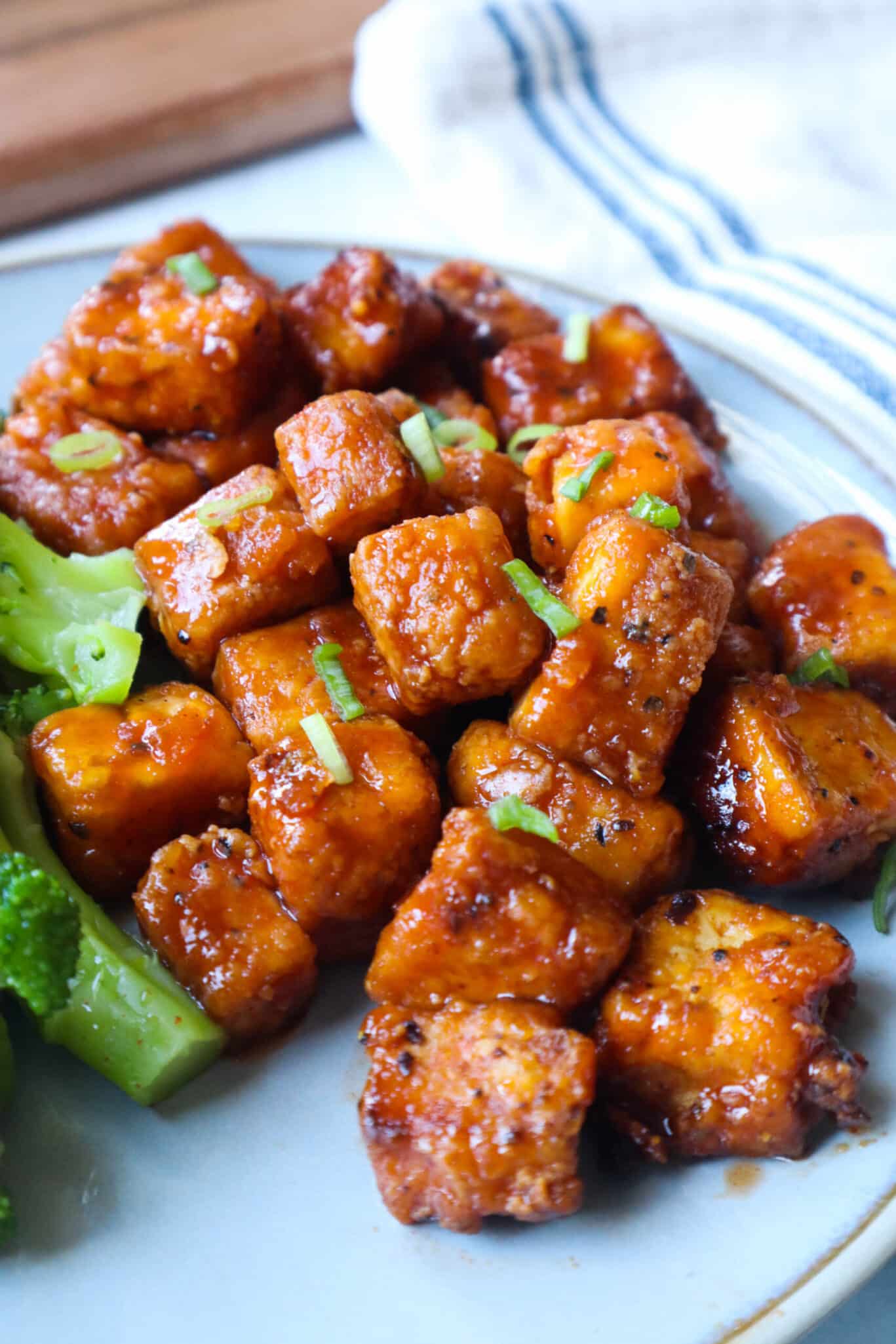 Tofu and broccoli on a plate.
