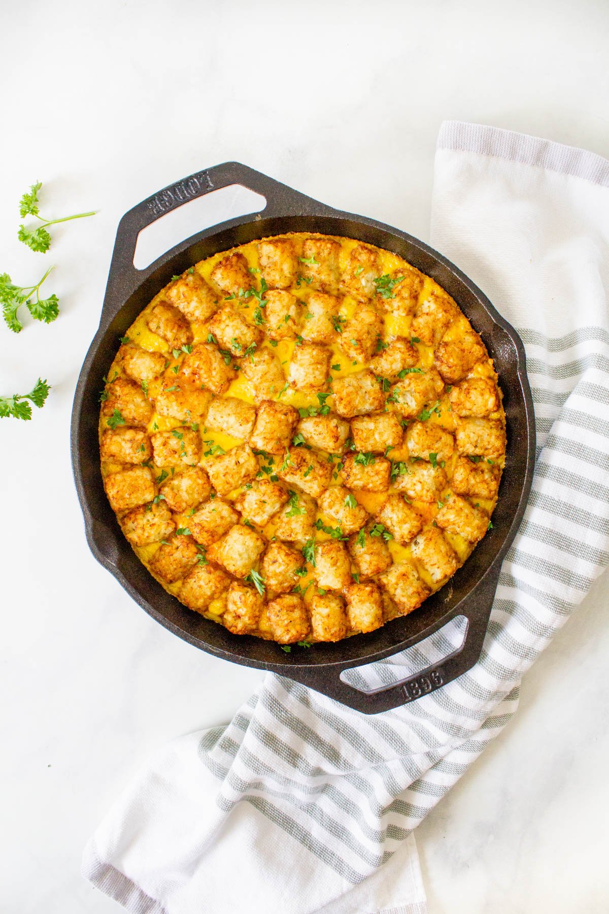 A cast iron skillet with a stuffed tater tot casserole.