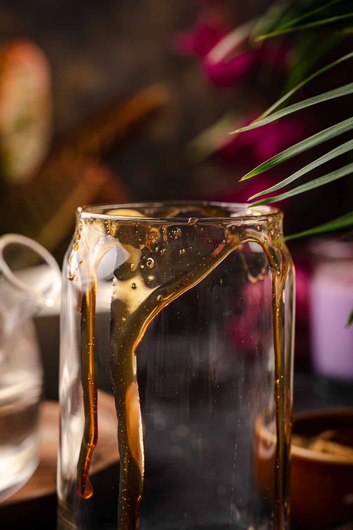 Brown sugar syrup tiger stripes dripping down a glass.