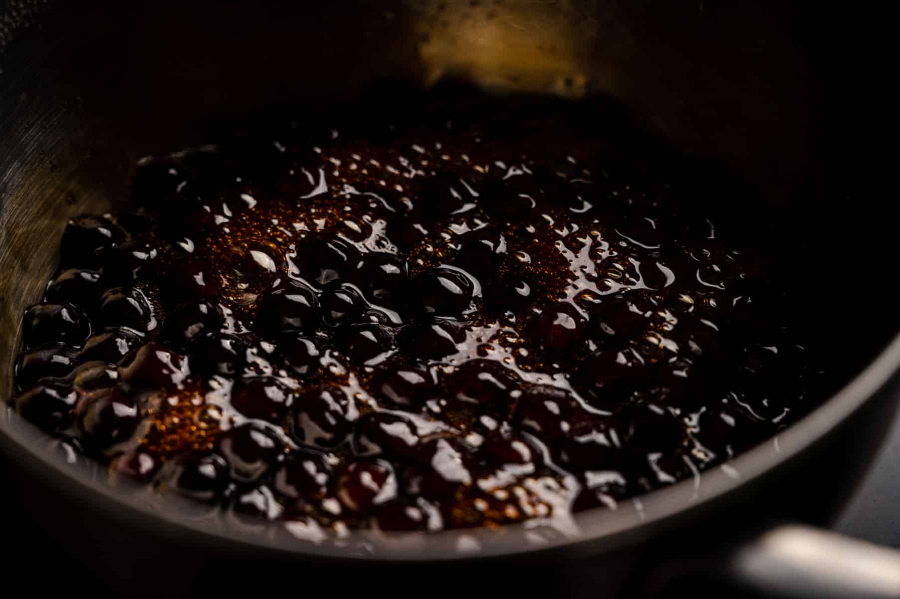 Tapioca pearls simmering in brown sugar liquid.