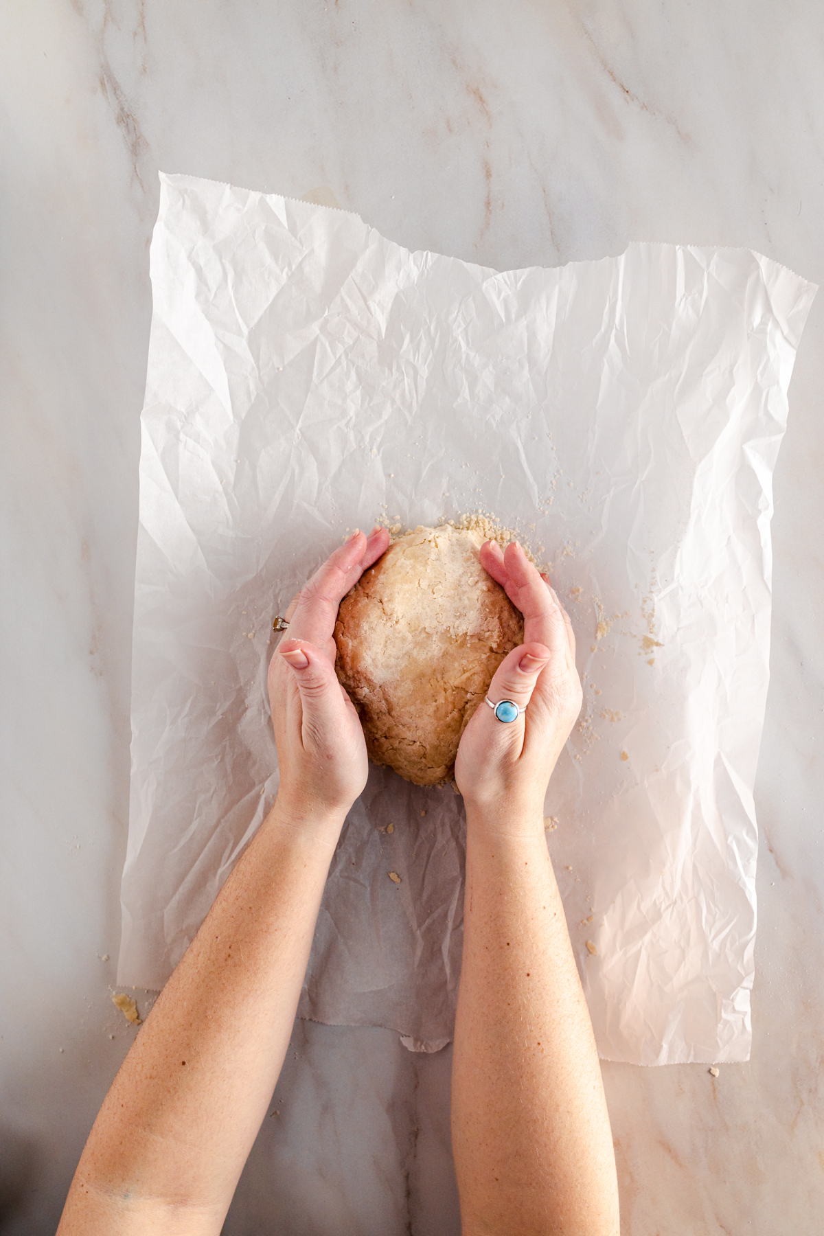 A person holding a doughnut on a piece of paper.