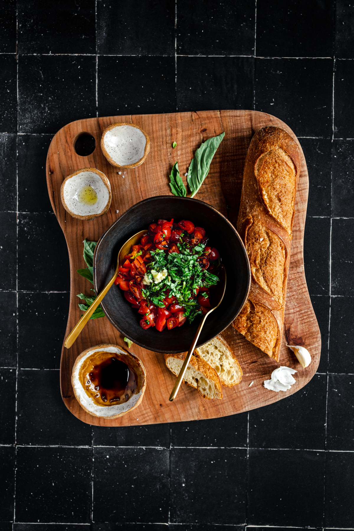 A bowl of tomato soup and bread on a wooden cutting board.