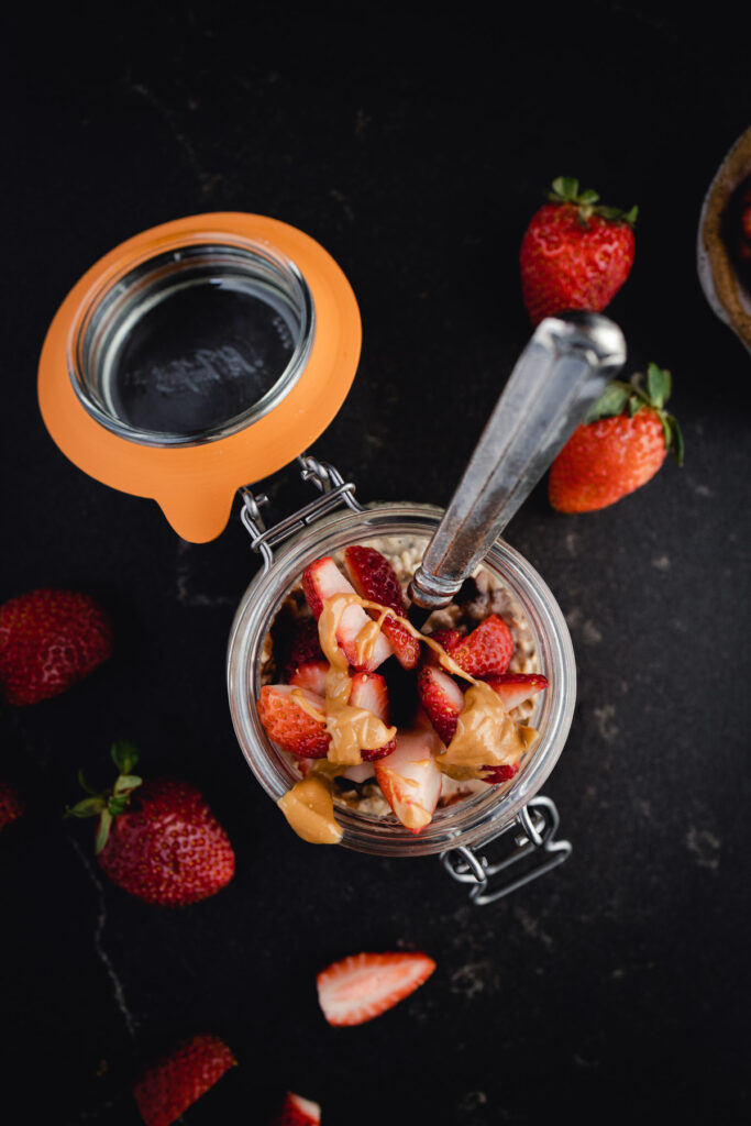 Fresh jar of overnight oats with berries and nut butter.