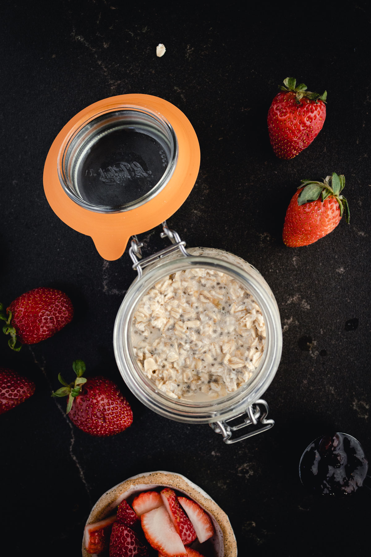 A bowl of oats with strawberries and raspberries.