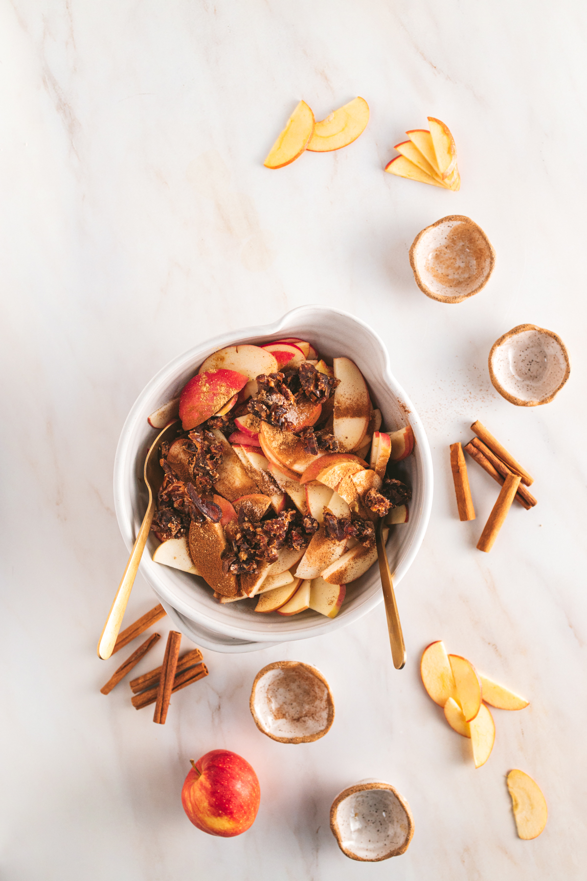 A bowl filled with apples and cinnamon.