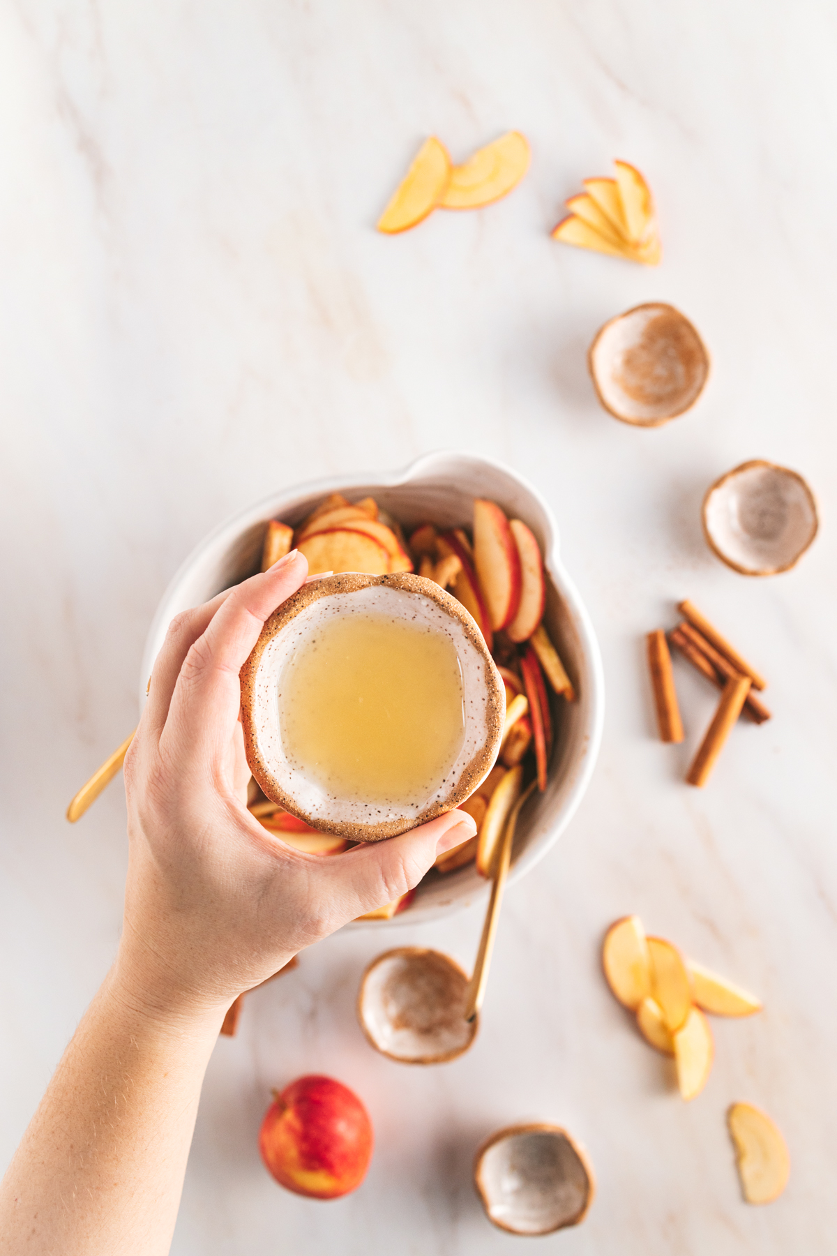 A hand holding a bowl of lemon juice over a large bowl.
