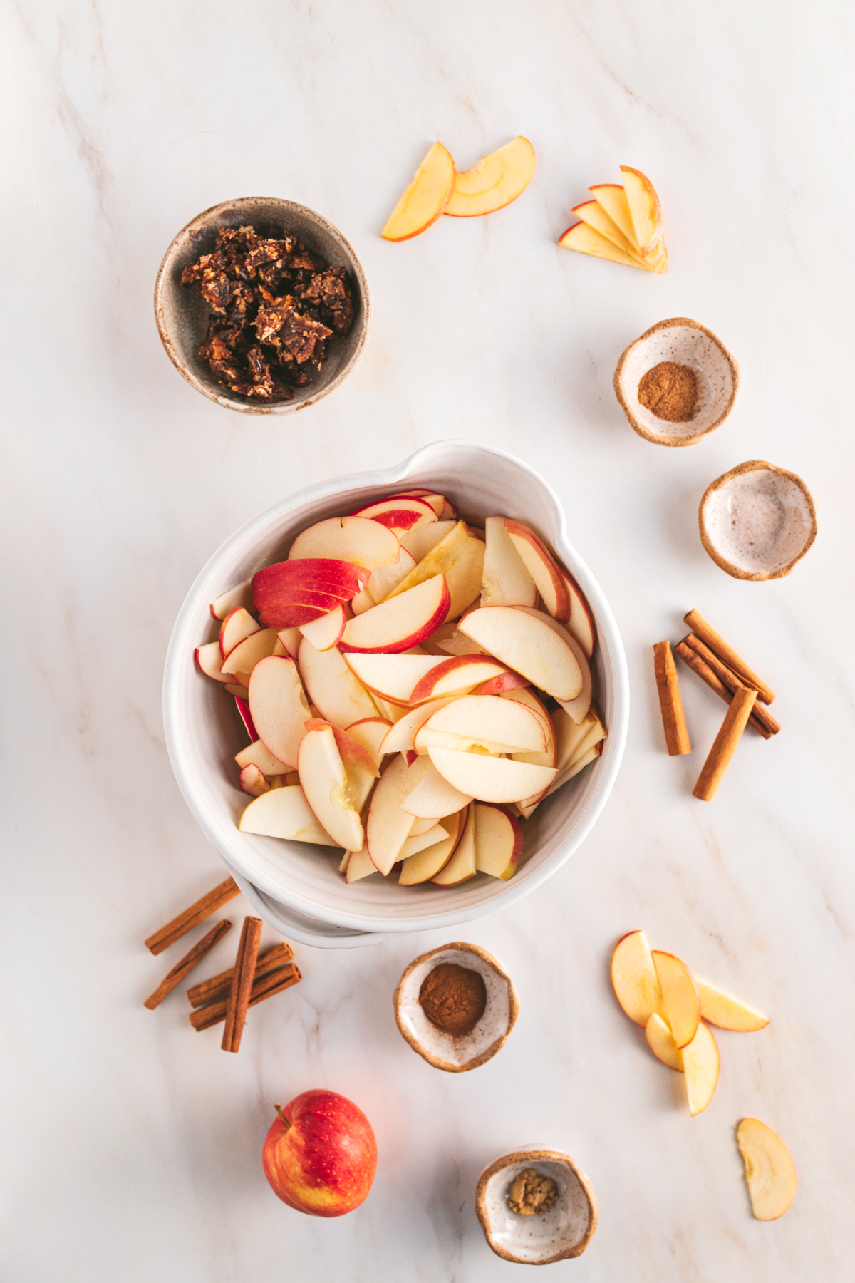 Apple slices in a bowl on a marble table.
