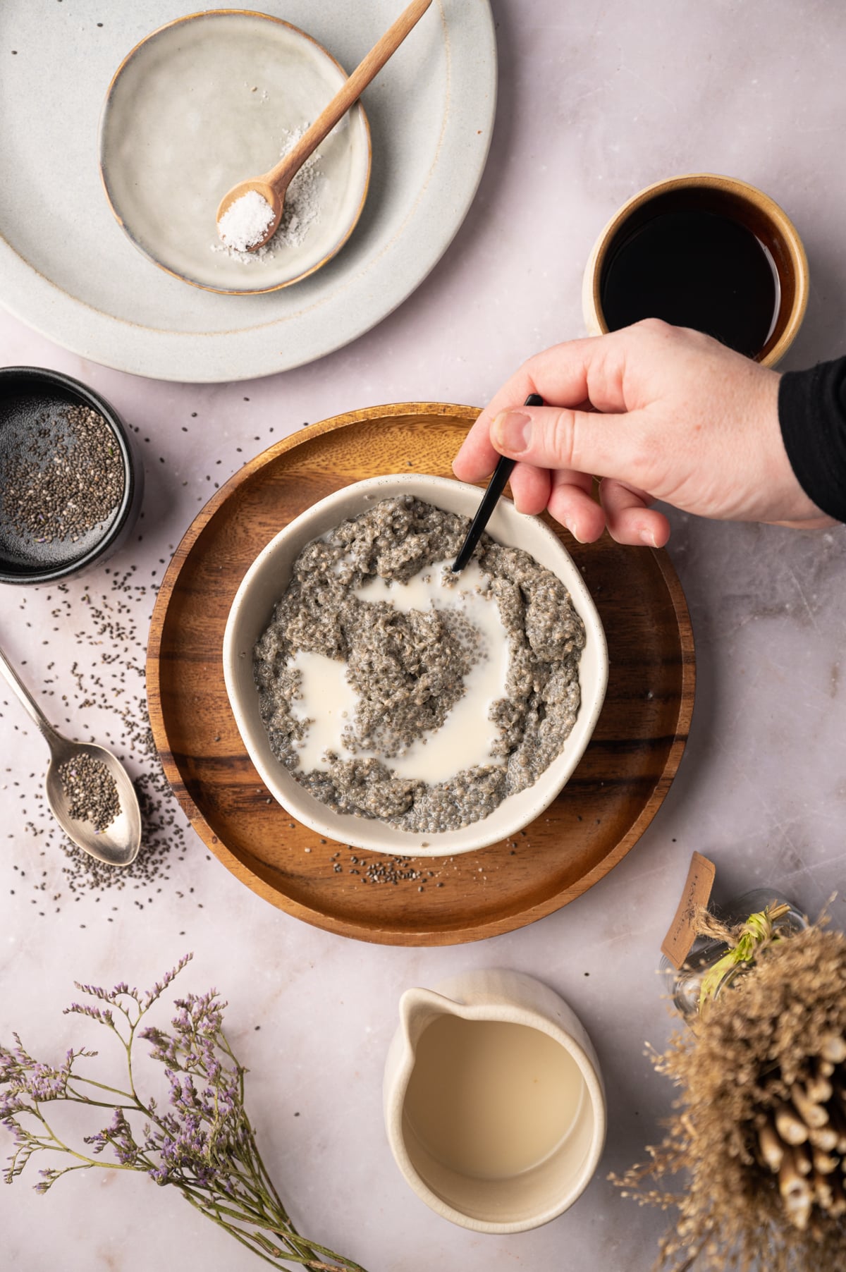 A person is mixing chia seeds in a bowl.