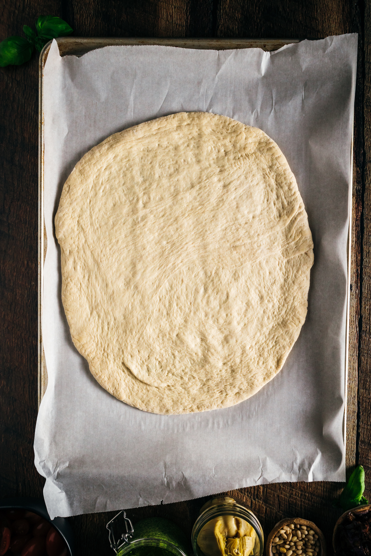 Homemade dough stretched out on a baking sheet.