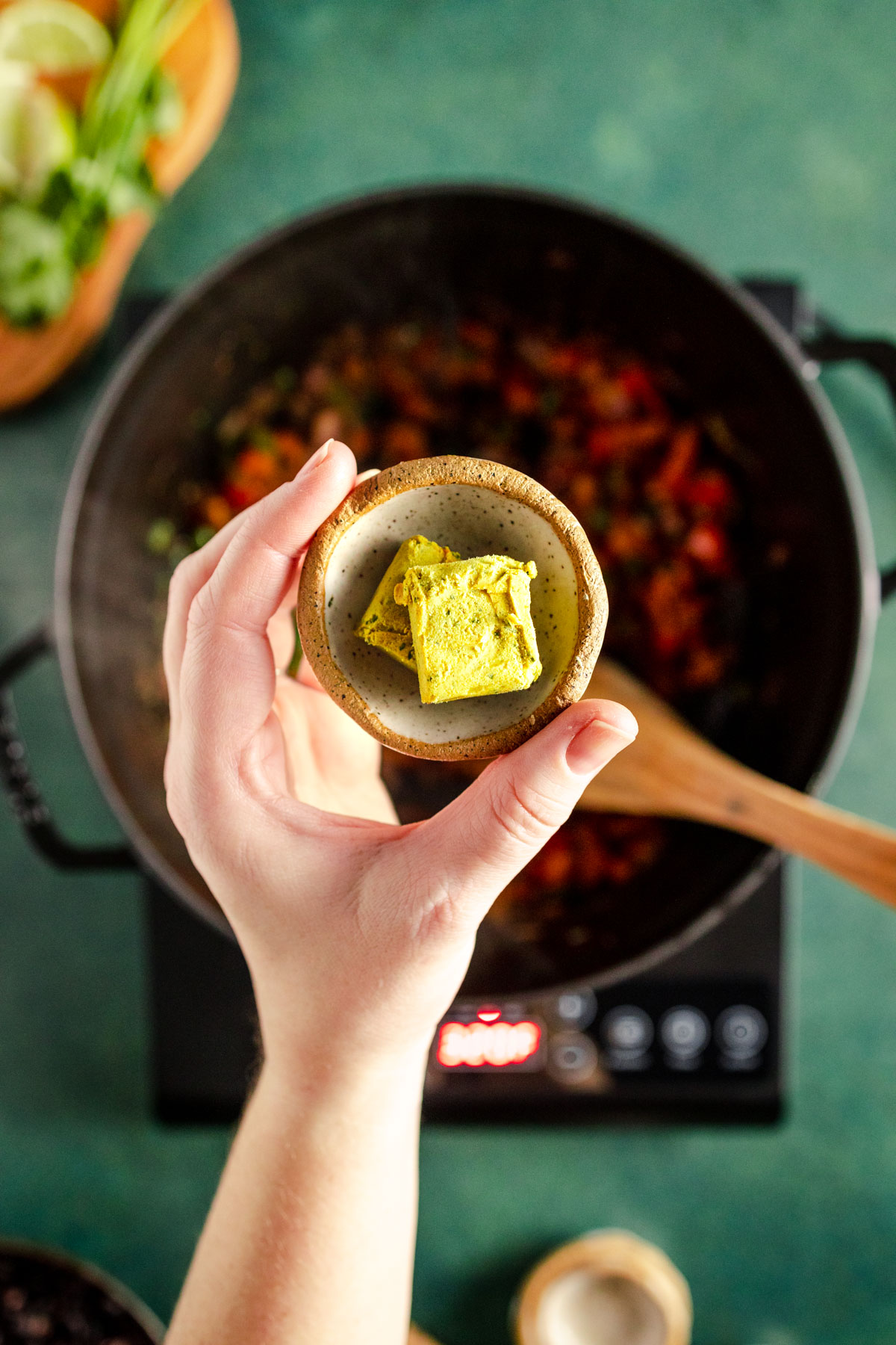 A person holding a vegetable bouillon.