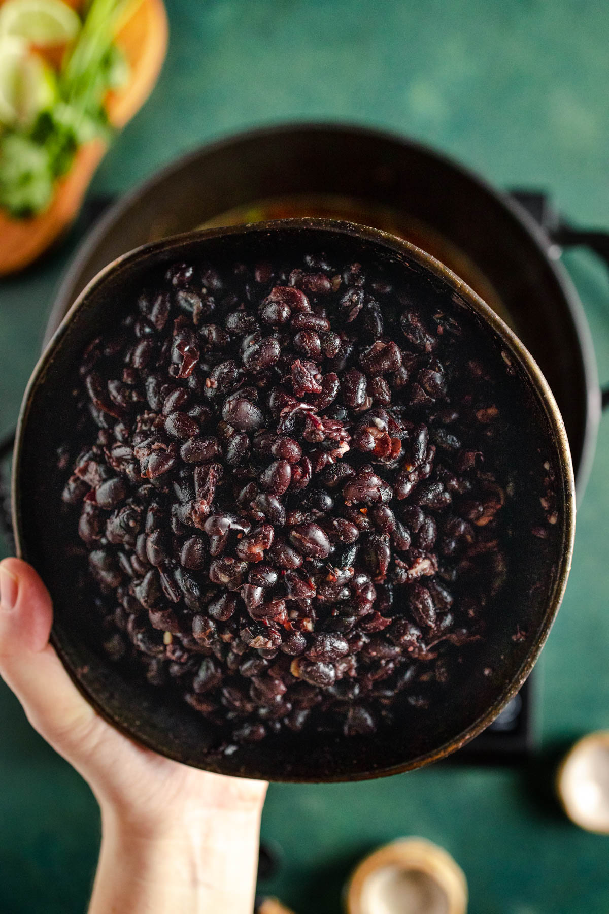 A person holding a pot of beans.