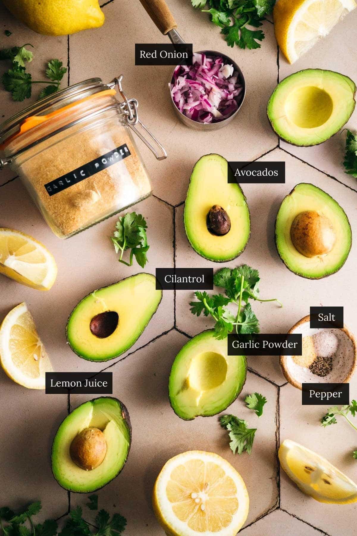 All of the ingredients for 5 minute guacamole recipe on a tile counter labeled.