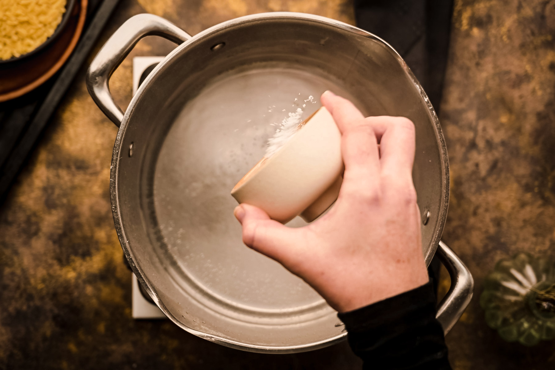 A person pouring water into a pot.