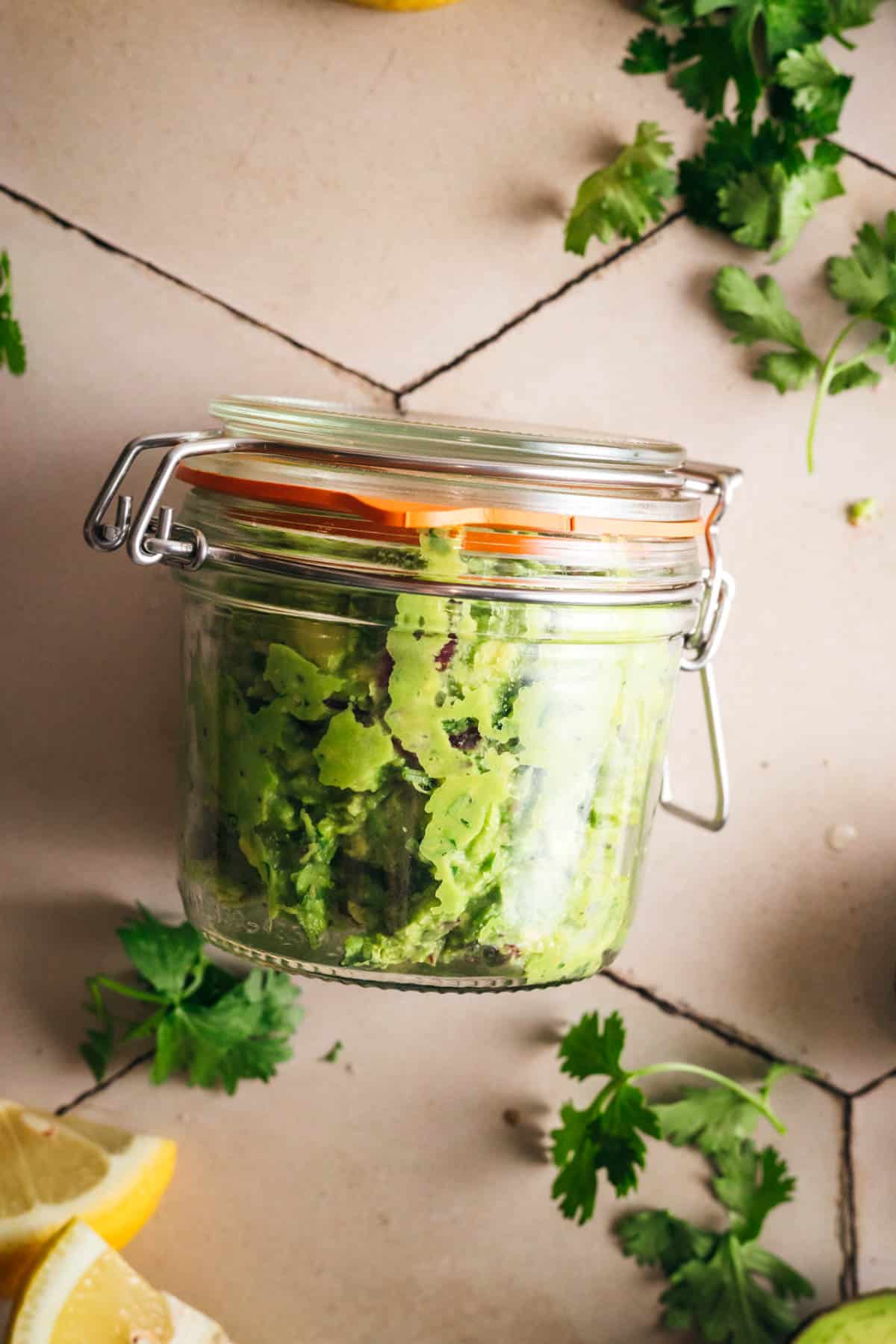 Sealing a glass jar full of the best guacamole recipe.