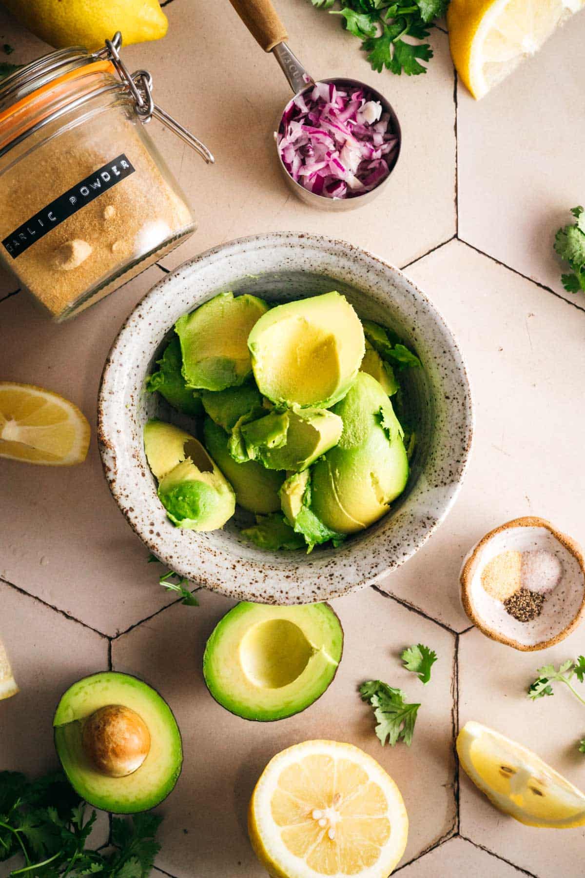 Scooping fresh avocado into a bowl.