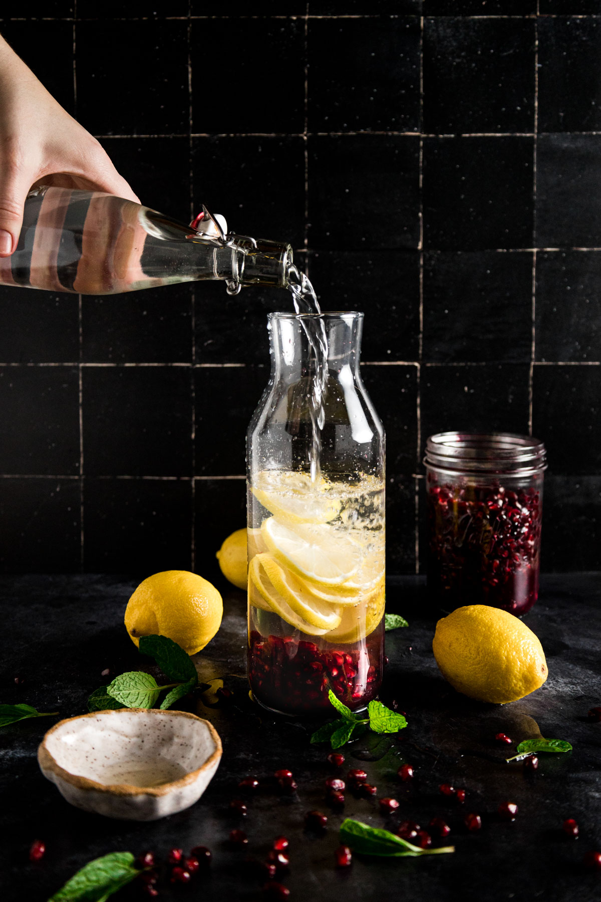 A person pouring pomegranate juice into a glass.