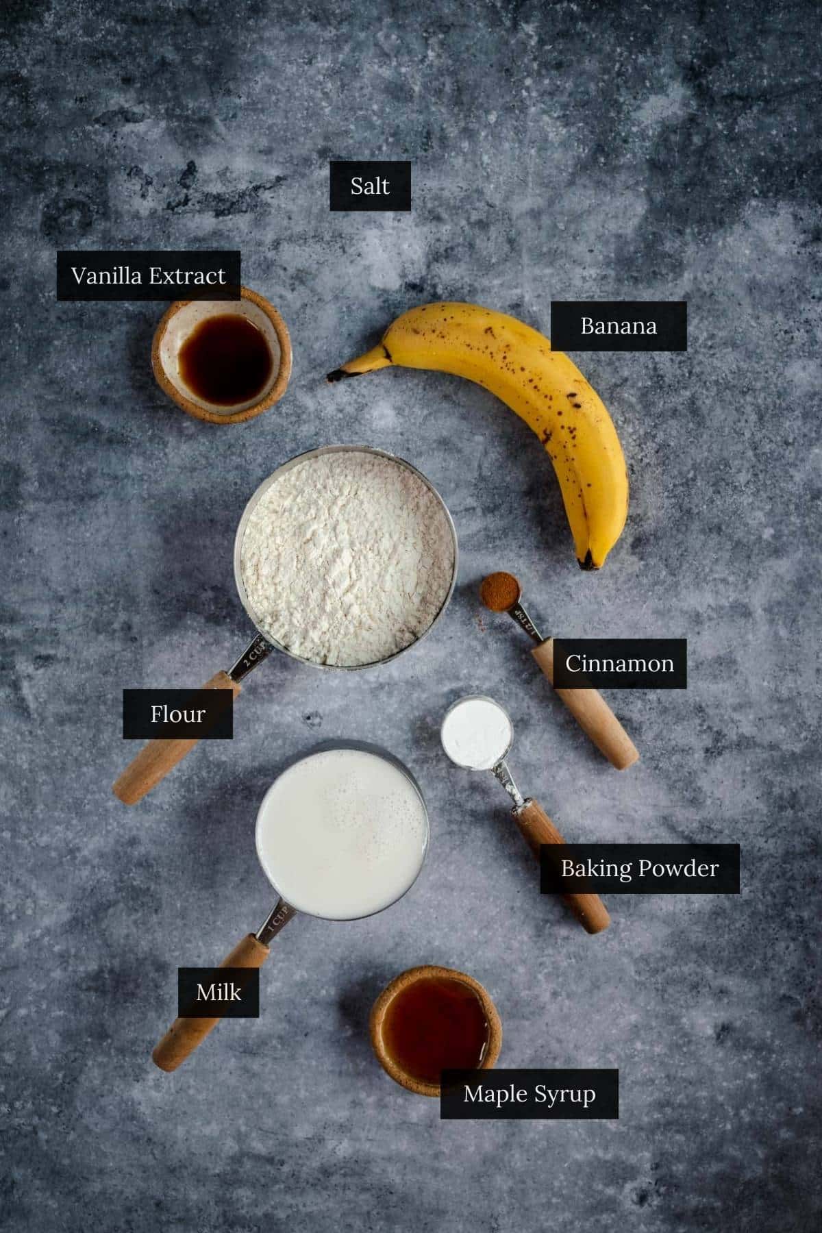 Ingredients for baking arranged neatly on a textured gray surface.