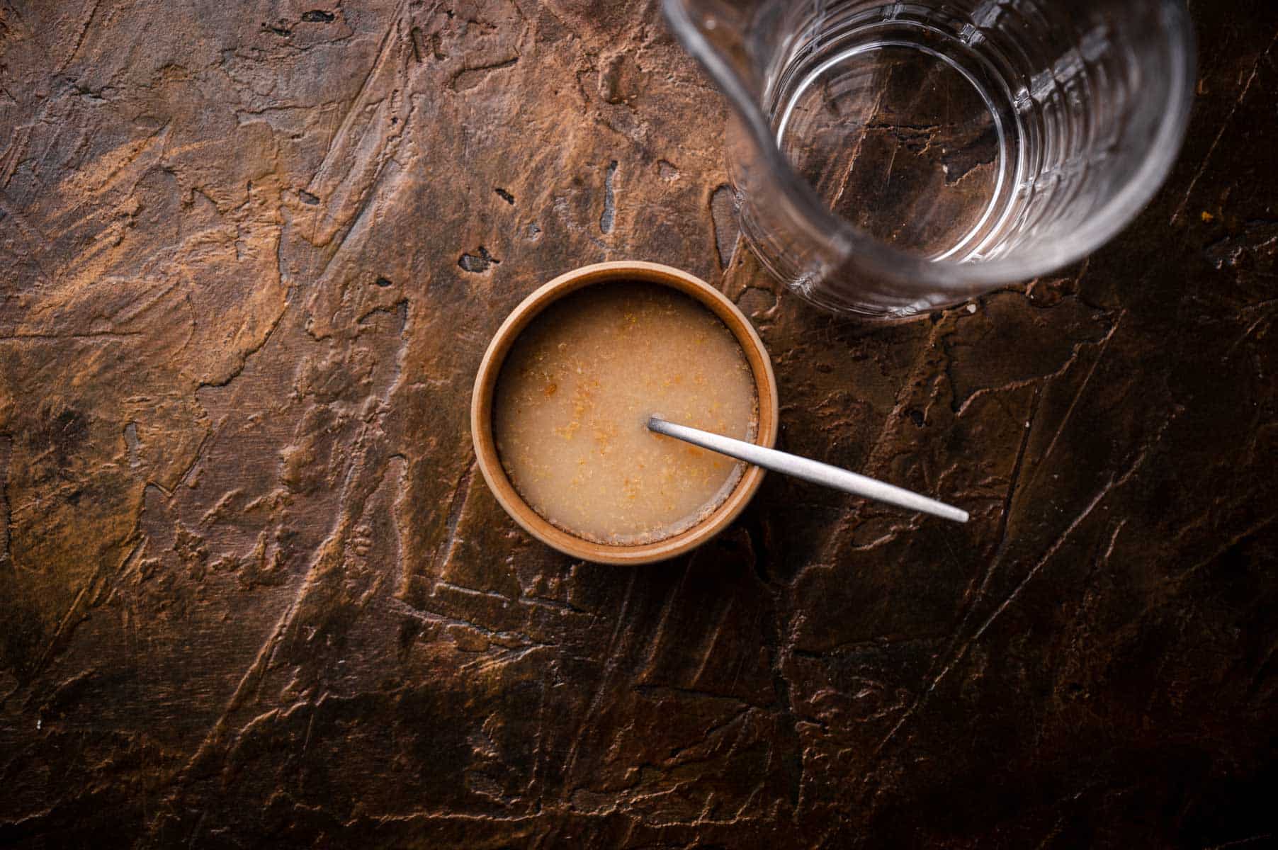 A small bowl of water and ground flaxseed mixed together.