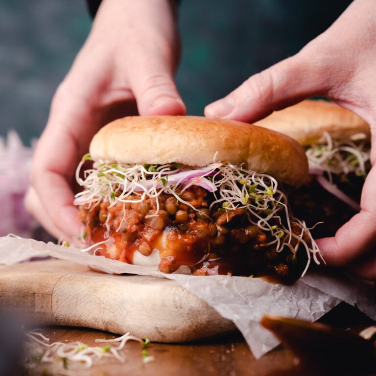 Woman picking up a sloppy joes burger.