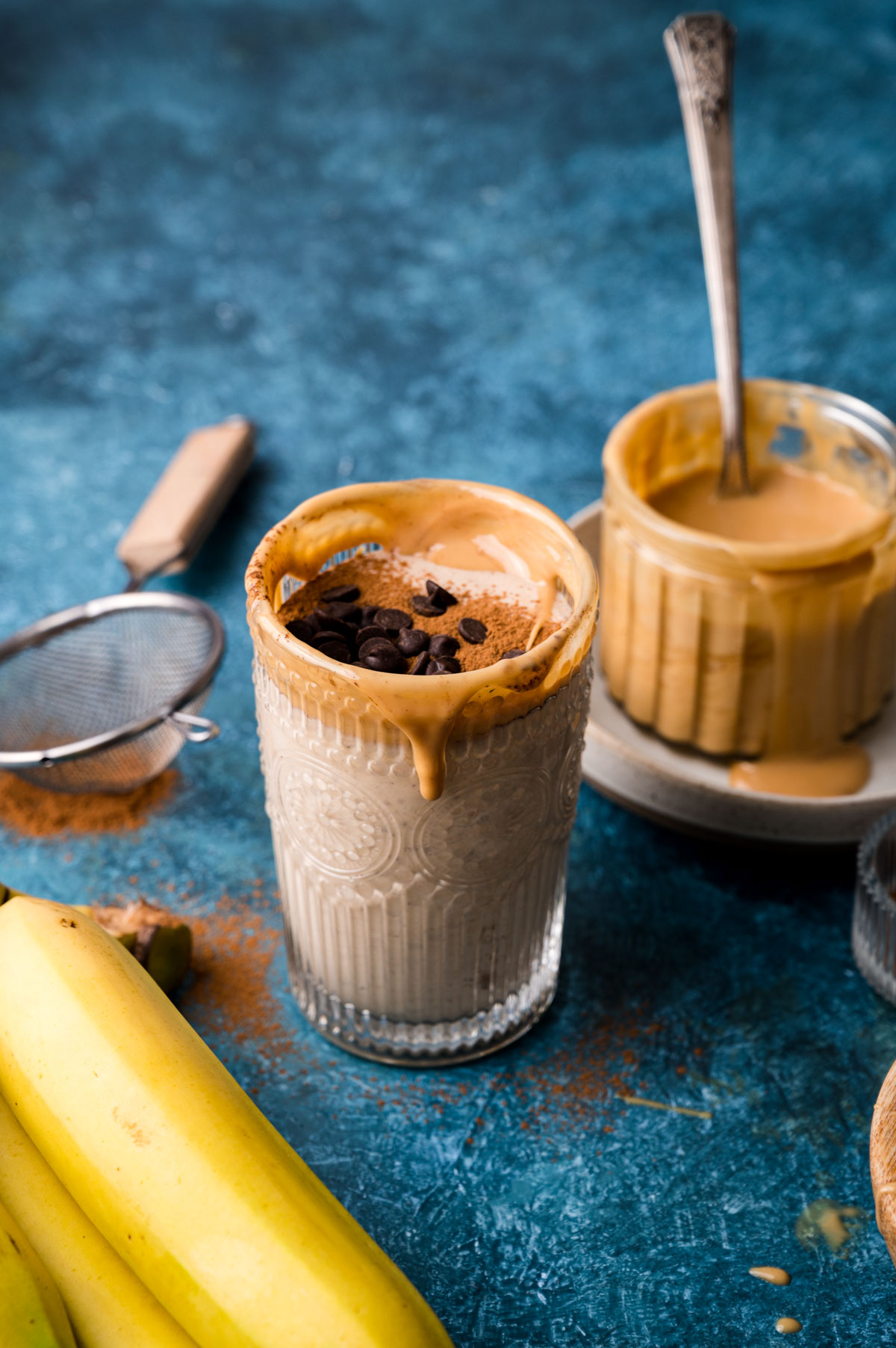 Almond butter banana smoothie recipe topped with almond butter and chocolate chips.