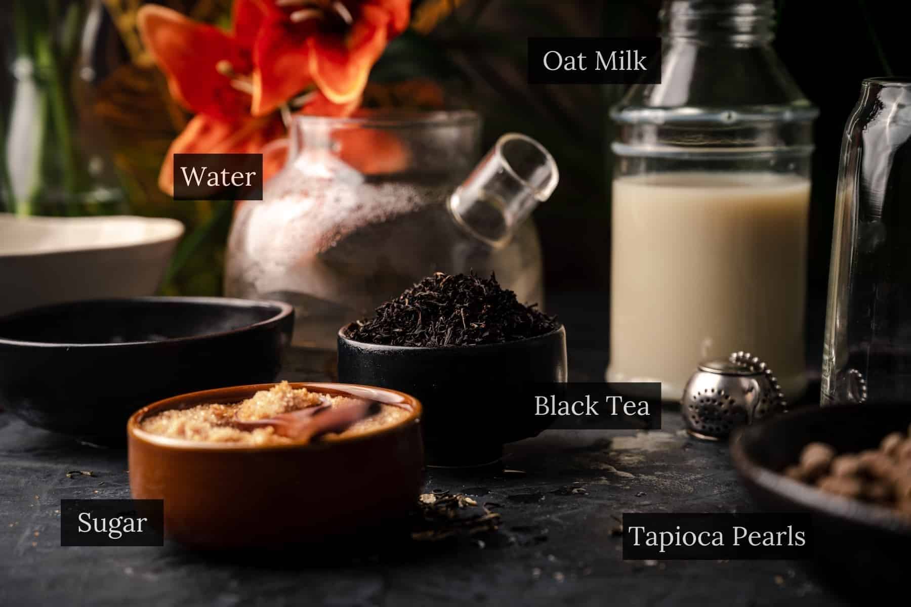 Ingredients for making bubble tea, including black tea, water, oat milk, cane sugar, and tapioca pearls.