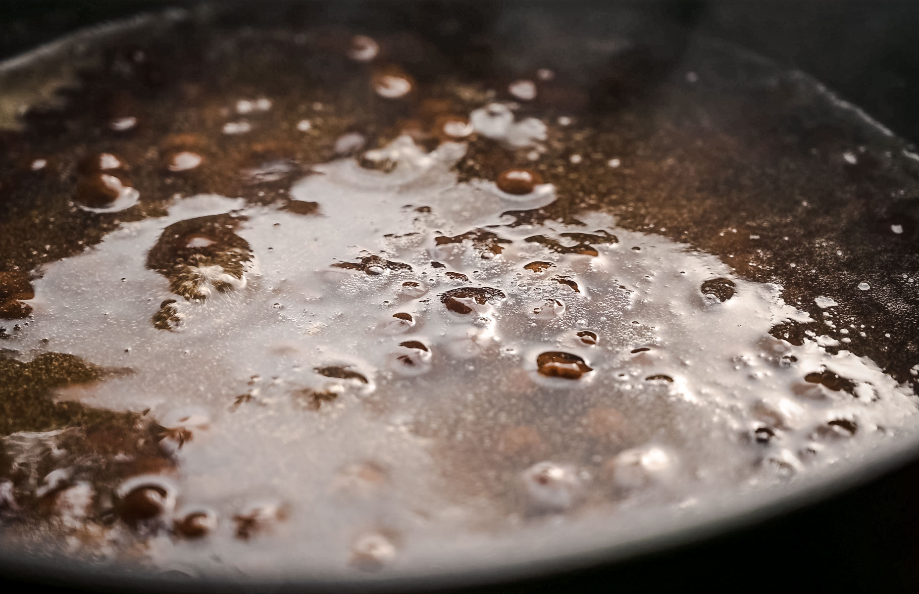 A simmering pot with bubbling tapioca pearls on the surface.